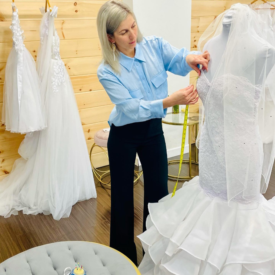 Cristina Grecu working on a bridal gown in the showroom